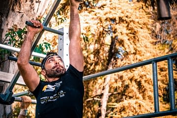 homme port un t-shirt noir, il fait une course à obstacle