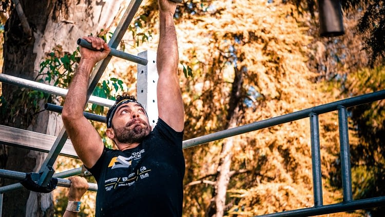 homme port un t-shirt noir, il fait une course à obstacle